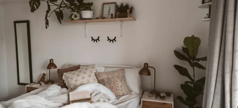 Harmonisk inredning sovrum med naturmaterial, ljusa textilier, gröna växter och mjuk belysning som skapar lugn och värme.